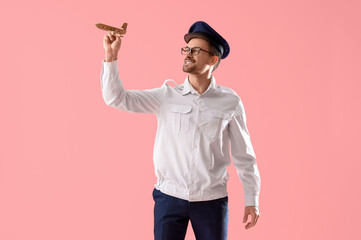 Sticker - Portrait of male pilot with wooden airplane on pink background