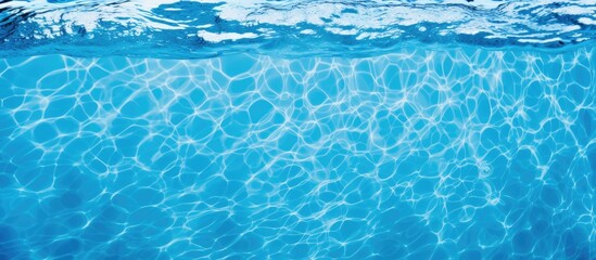 Wall Mural - A closeup of the azure liquid in a swimming pool, displaying the fluidity of the water in its electric blue hue. Underwater marine biology in a recreational setting