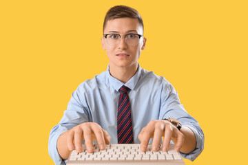 Sticker - Funny businessman using computer keyboard on yellow background, closeup