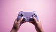 © COC STUDIO - Woman's hands holding game controller playing video games isolate on pink background.