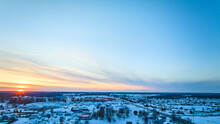 Aerial Winter Sunrise Over Snowy Suburban Neighborhood
