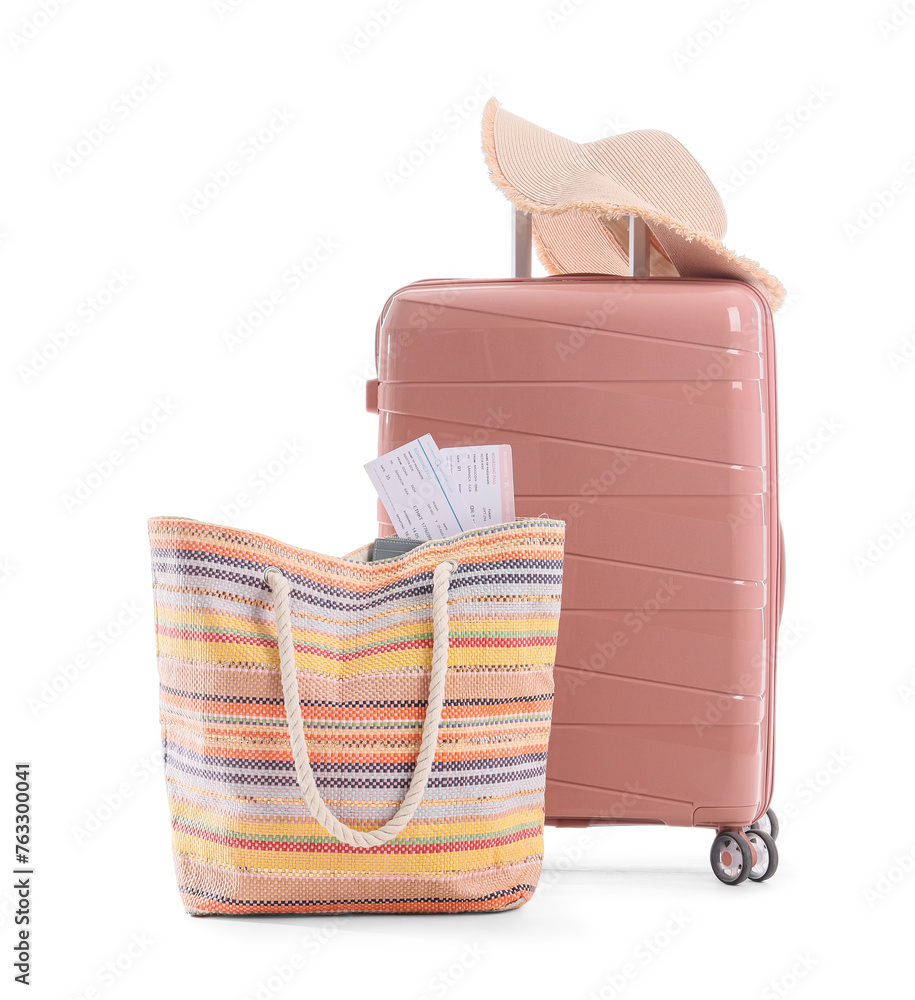 Suitcase with summer hat and beach bag on white background