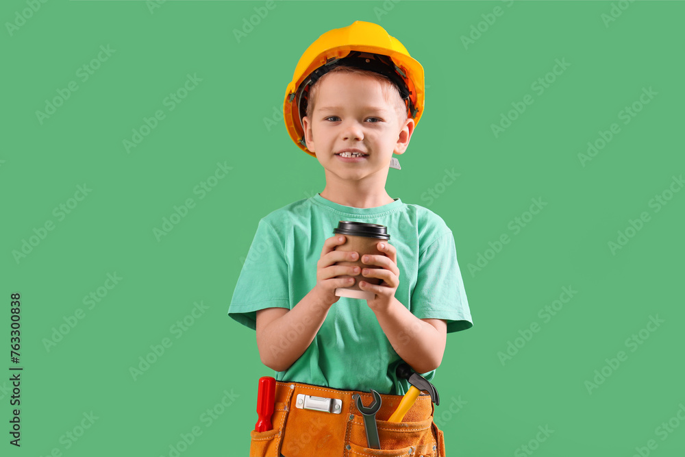 Cute little builder with coffee cup on green background