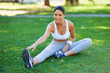 © Duncan M/peopleimages.com - Woman, athlete and stretching in park with earphones for music in portrait, fitness and ready for cardio outdoor. Warm up, start run and listening to radio, sport and flexibility on lawn for exercise