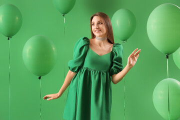 Canvas Print - Young woman with balloons on green background