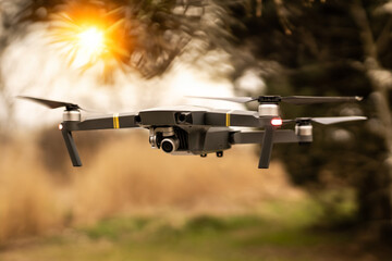 Wall Mural - man operating drone/man holding remote control drones/drone controller with sunset background.