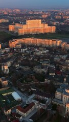 Wall Mural - Vertical aerial drone view of Palace of the Parliament in Bucharest downtown at sunset. Romania