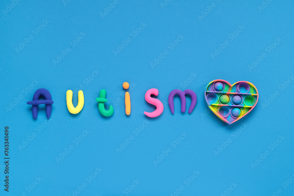Plasticine word AUTISM and pop it on blue background