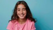 © Keat - brown haired latin girl Cute young Hispanic student wearing pink shirt looking at camera laughing standing isolated on blue background.