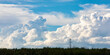 © Designpics - Large storm clouds forming on the horizon behind large power transmission lines on a warm summer evening; Edmonton, Alberta, Canada