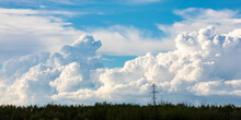 Large Storm Clouds Forming On The Horizon Behind Large Power Transmission Lines On A Warm Summer Evening; Edmonton, Alberta, Canada