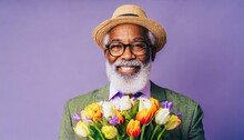 Senior Bearded Old Man Wearing Framed Eyeglasses With A Bouquet Of Flowers Smiling At The Camera, Isolated On Lilac Background