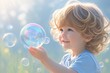 © kenkuza - cute toddler boy playing with soap bubbles on summer field