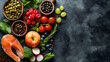 Healthy food background. Fresh vegetables, fruits and fish on black stone table.