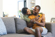© Wavebreak Media - A young African American couple shares a cozy moment on the sofa at home with copy space