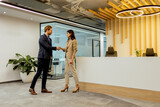 Fototapeta Przeznaczenie - Two professionals exchanging greetings with a friendly handshake in a sleek office environment