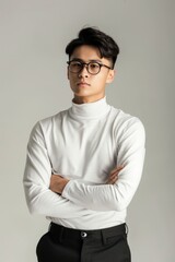 Wall Mural - Asian man wearing a white shirt and black pants stands relaxed outdoors