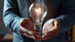 Close-up shot of a businessman's hands holding a futuristic light bulb, symbolizing the visionary approach to business powered by advanced technology