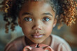 Portrait of little african american girl embracing her gold piggy bank while lying down on the floor looking at camera smiling