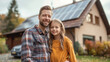 © aekkorn - Family with little girl standing in front of their house with solar panels on the roof, having electric car.