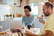 © Davor - Couple having breakfast together while woman uses laptop in the kitchen at home