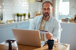 © Davor - Middle aged Caucasian man using laptop at home