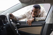 © Home-stock - Black guy looks at the interior of the car, choosing a new car Selective Focus