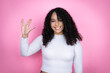 African american woman wearing casual sweater over pink background doing star trek freak symbol
