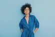 Full body photo of an attractive woman in her late thirties wearing a blue jumpsuit with short curly hair