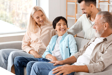 Poster - Little boy with his family sitting on sofa at home