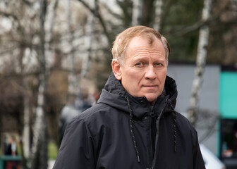 autumn portrait of a mature handsome man against the background of a park