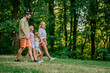 © Zamrznuti tonovi - A young family holding hands and going for a walk in nature.