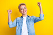 Photo portrait of pretty young girl raise fists champion winning wear trendy jeans outfit isolated on yellow color background