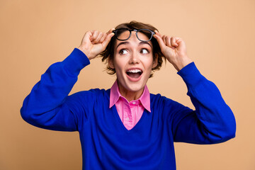 Poster - Photo portrait of attractive young woman take off specs look amazed empty space wear trendy blue clothes isolated on beige color background