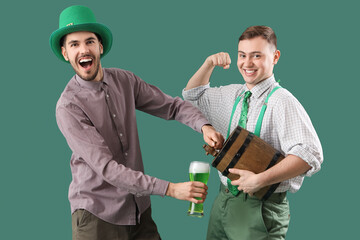 Poster - Male friends pouring beer from barrel on green background. St. Patrick's Day celebration