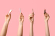 © Pixel-Shot - Female hands with lipstick, lip gloss and eyeliners on pink background
