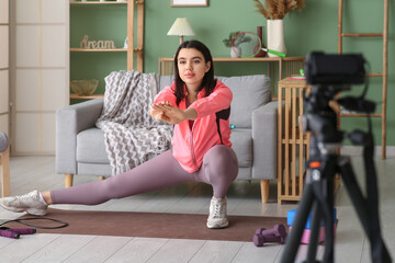 Wall Mural - Female blogger on mat recording sports video at home