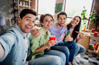 © deagreez - Photo of idyllic positive buddies sitting couch hug drink beer eat pizza make selfie daylight house indoors