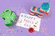 Poster with text HAPPY FOOL'S DAY, Mexican pinatas and confetti on lilac background