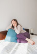 © darkbird - Sad woman sitting on the bed at home