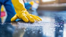 Hygiene-focused cleaning using spray detergent and rubber gloves, underscoring the importance of maintaining cleanliness on work surfaces