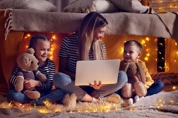 Sticker - Mother and her children with laptop in play tent at home