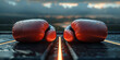 Red boxing gloves on dark floor with light, background with clouds.