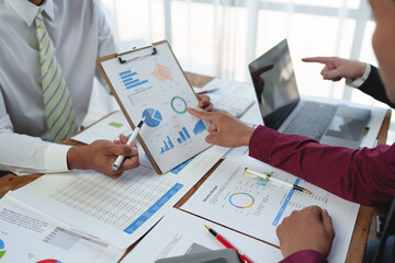 Wall Mural - A group of Asian businessmen are meeting, planning and discussing data analysis, growth charts, graphs, financial calculations, marketing, revenue management. Various taxes within the joint office.