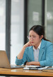 © crizzystudio - Young independent businesswoman with glasses is tired, stressed, has a headache while sitting in front of a laptop for a long time and working in finance. Online. Office Syndrome concept.