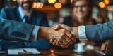 Fototapeta Miasto - Confident business partners sealing successful partnership with a firm handshake in modern office setting