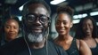 © AdriFerrer - Smiling older man with headphones in a gym, group of women behind.