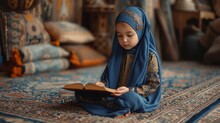 A Young Child, Draped In A Beautiful Blue Hijab, Concentrates On Reading A Book, Surrounded By The Rich Textures Of An Ornate Carpet. Her Cultural Attire And The Traditional Setting Evoke A Sense Of
