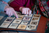 Fototapeta  - An elderly couple scrolls photos on a family album at home