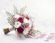 Wiązanka ślubna z bordowymi kwiatami i ozdobnymi liśćmi